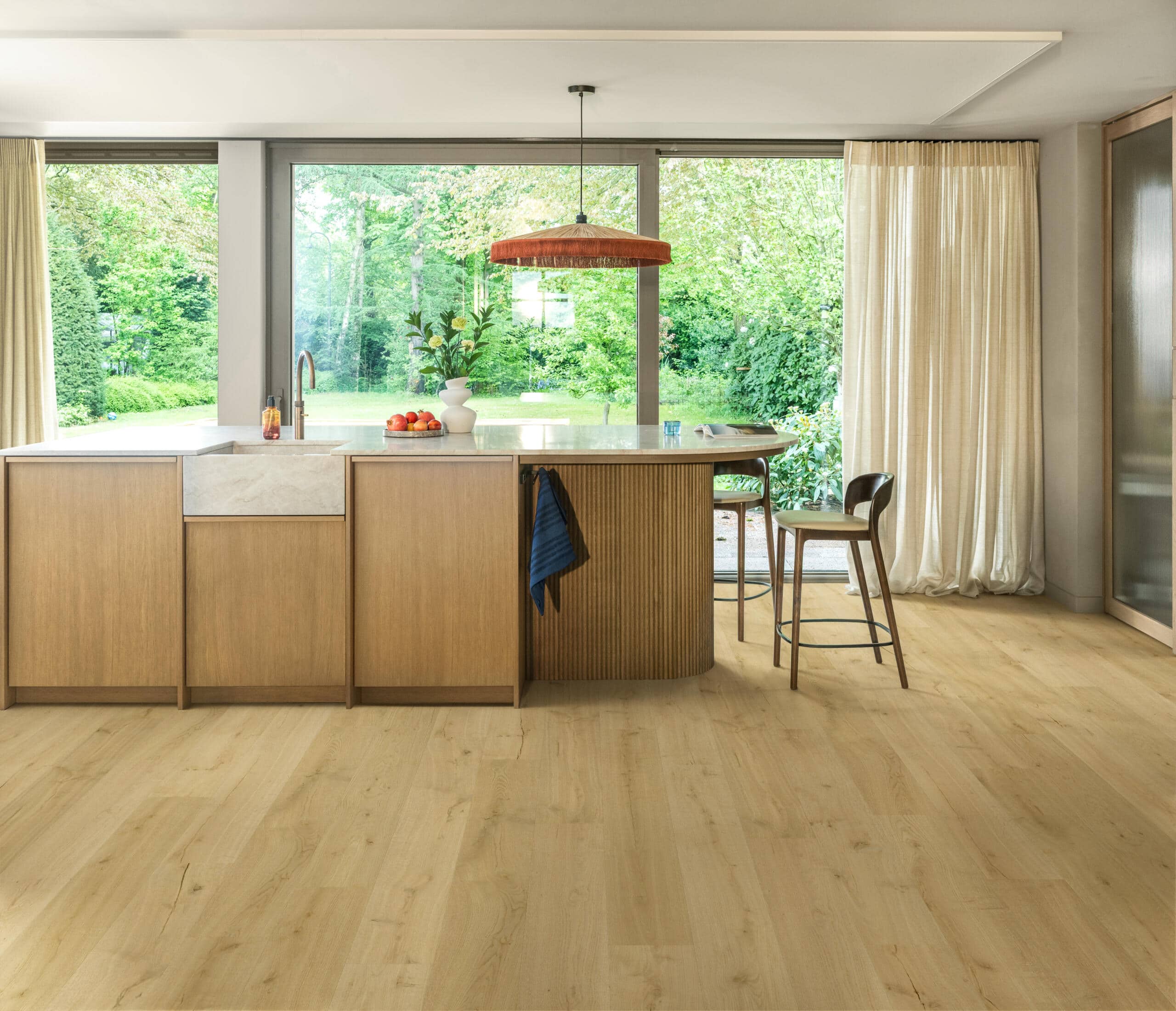 Blog Quick-Step Almond Oak waterproof laminate flooring in a staged modern kitchen with a fluted wooden island, installed by Titan Timber Flooring Perth.