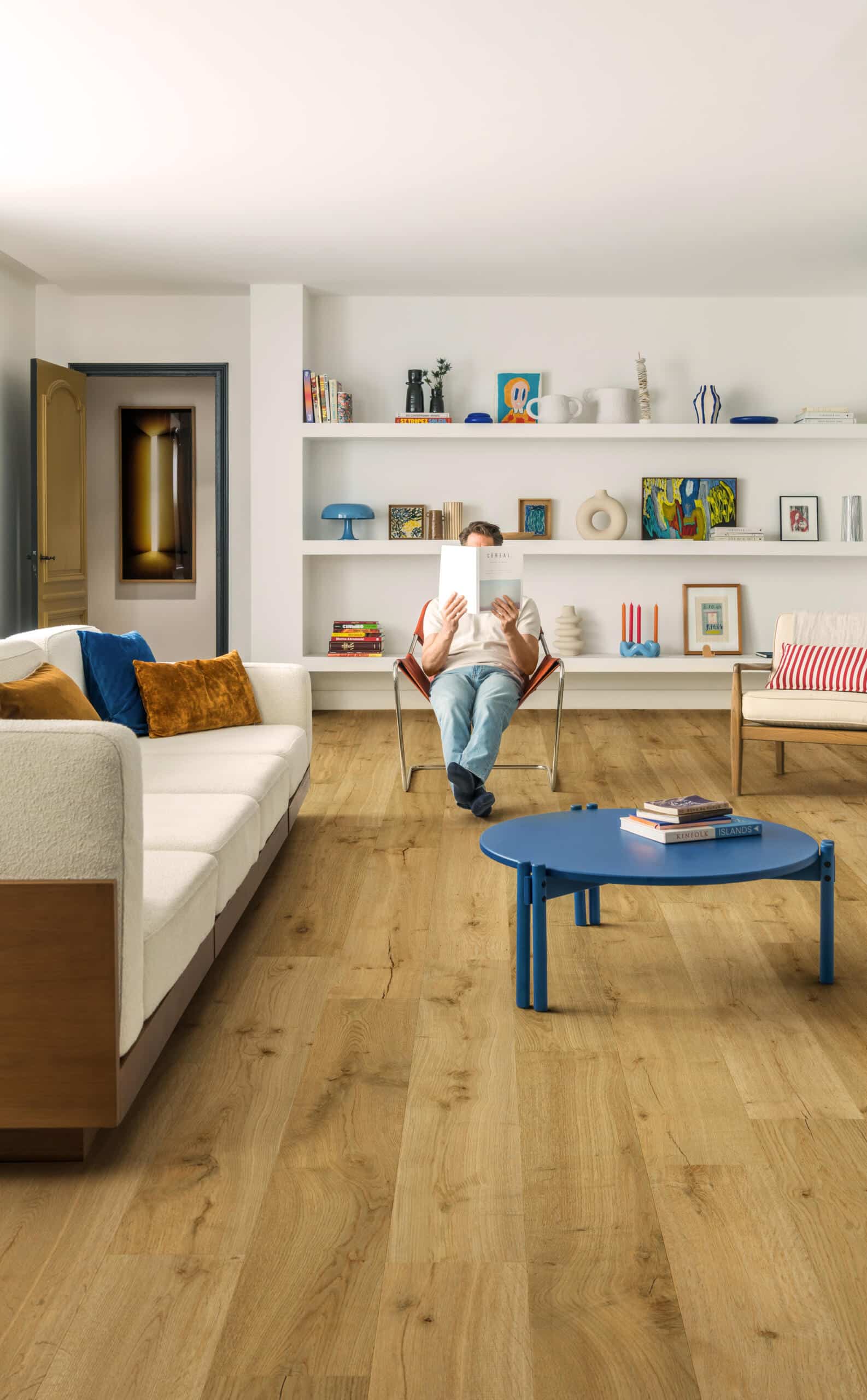 Blog Quick-Step Truffle Oak waterproof laminate flooring in a modern living room with white shelving, installed by Titan Timber Flooring Perth.