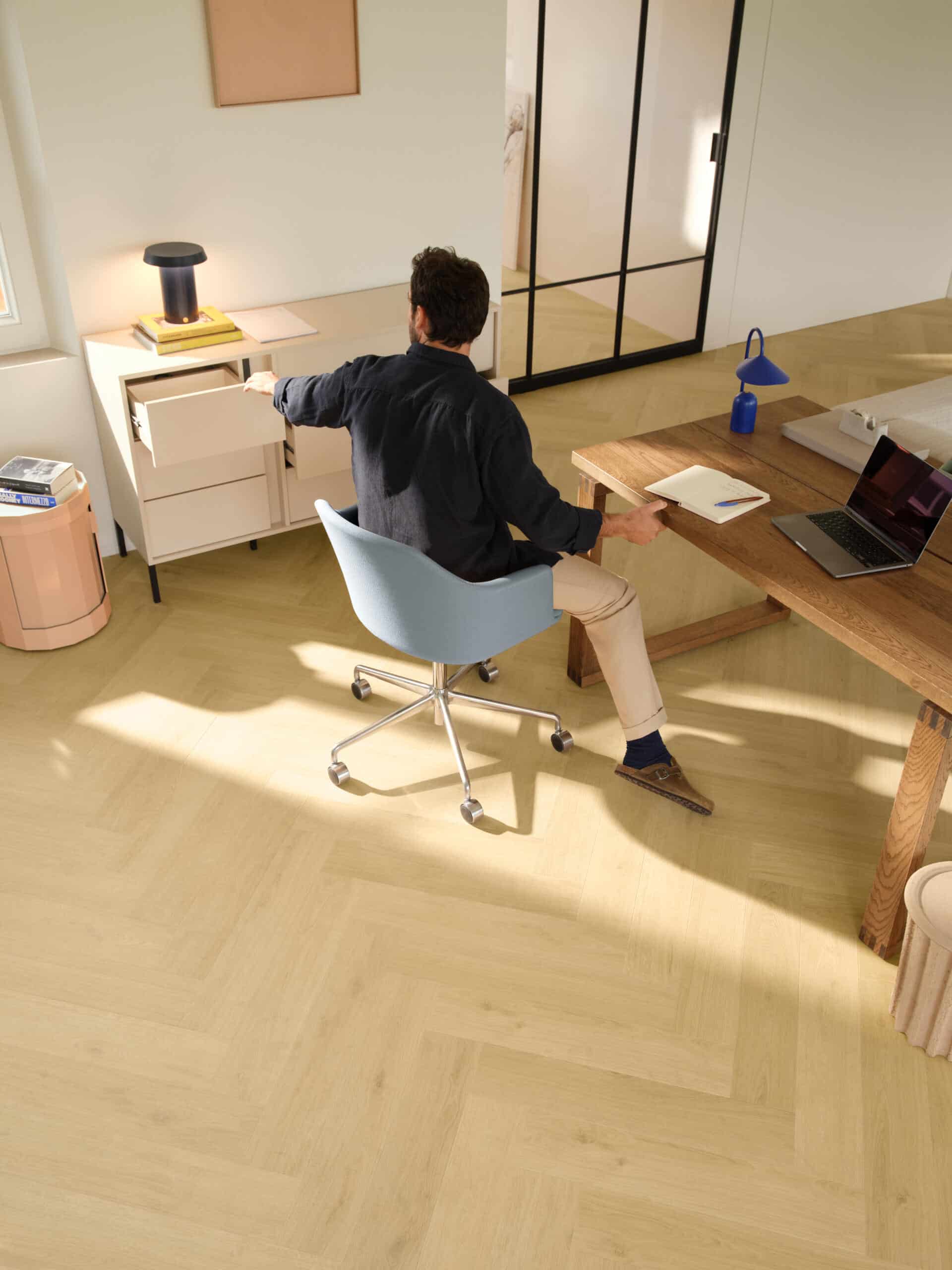 Blog Quick-Step Ginger Oak waterproof laminate flooring laid in a herringbone pattern in a modern home office space, installed by Titan Timber Flooring Perth.